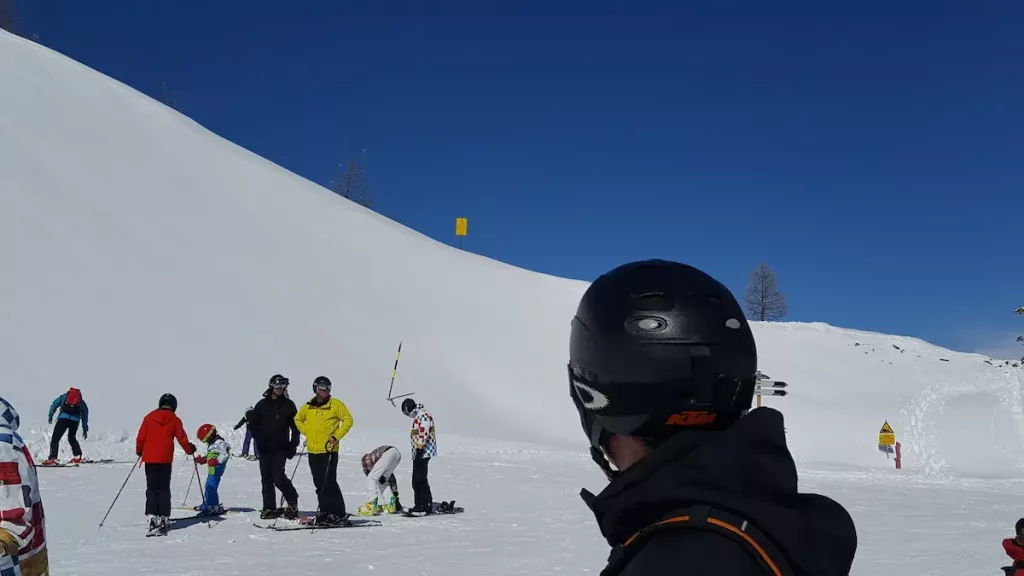 skieur casque de dos regardant l'horizon avant de reprendre sa descente de ski a isola 2000. la neige est epaisse et le ciel bleu marine. Isola 2000 et auron sont les principales rivales des stations du sud de la france....