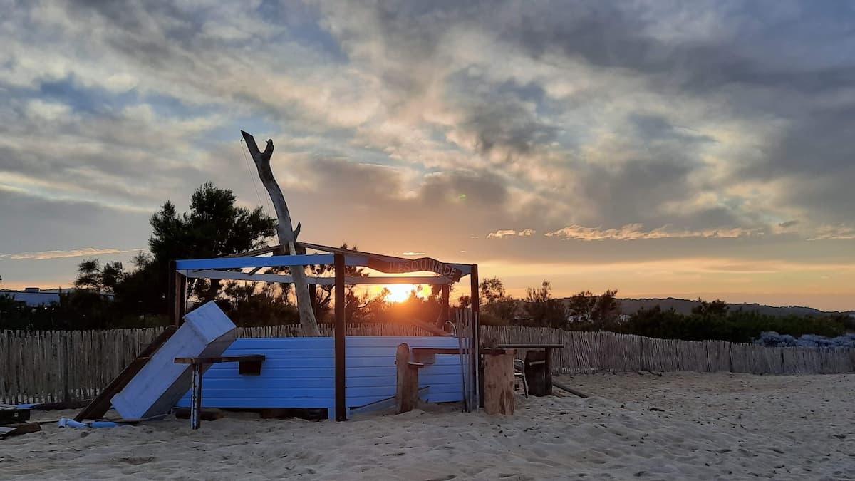 plage de pampelonne a ramatuelle hors saison ou on apercoit l'infrastructure des plages demontees sur le sable et un coucher de soleil enchanteur