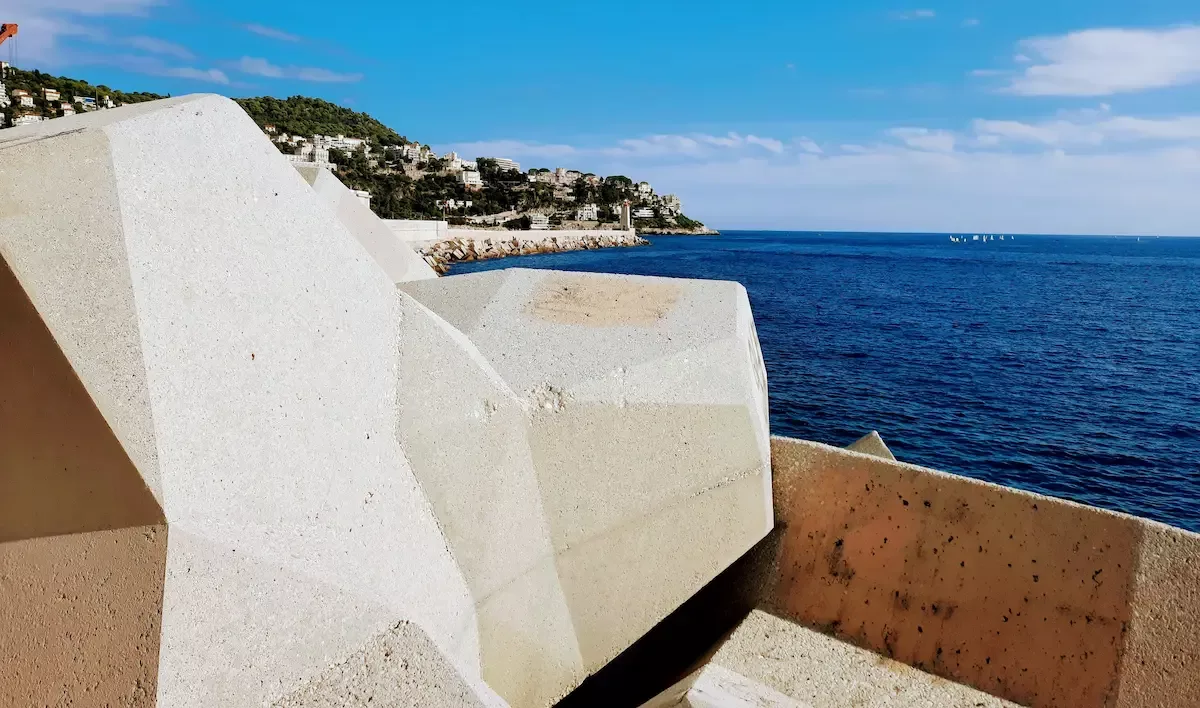 balade au port de nice le long des gros bloc de beton face au monument aux morts avec vue sur le mont boron