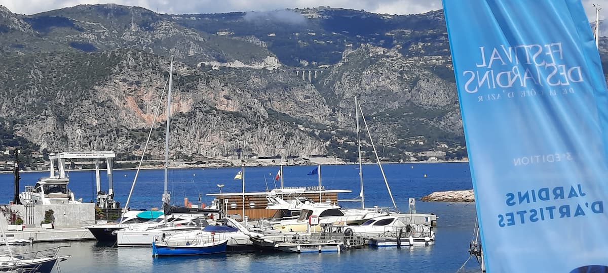 Une vue du port de St Jean Cap Ferrat avec les montagnes en fond. La presqu'île offre un très beau sentier littoral de randonnée pour admirer ces paysages spectaculaires.