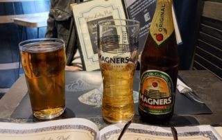 une bouteille de cidre irlandais magners et un coca poses sur une table au blue lady, un bar anglais tres anime situe a la galerie du port a antibes