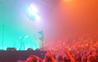 le groupe louise attack au palais nikaia devant une foule electrique et des jeux de lumieres fluo