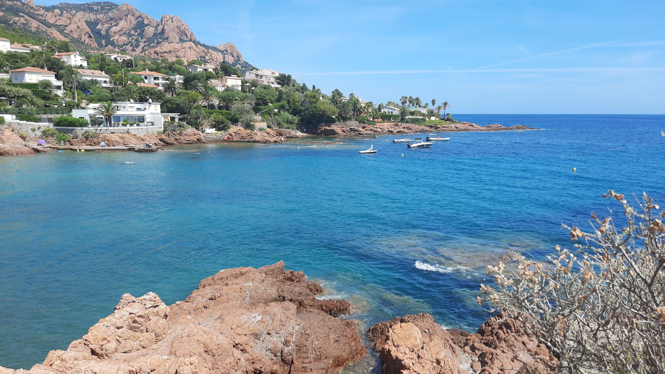 vue sur une crique de l'esterel ou le contraste entre les rouges couleur terre cuite et la mer turquoise est saisissante