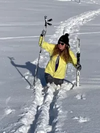skieuse de fond dans neige profonde pour rejoindre la voiture apres une chute skis et batons a la main