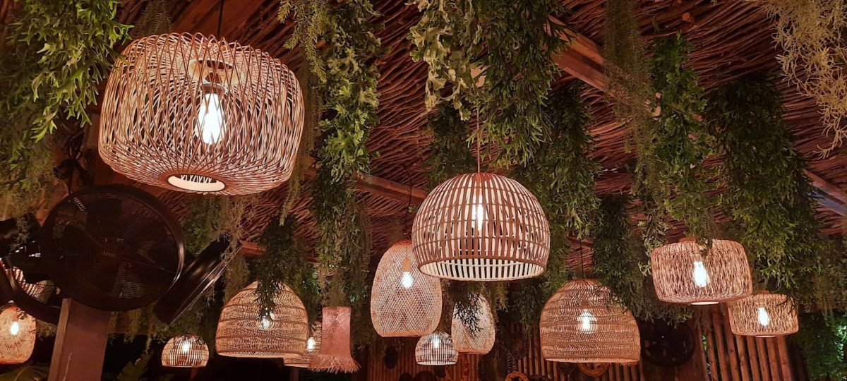 ensemble de luminaires en paille tressee accroche avec des vegetaux sur le plafond de du resto plage batik a beaulieu sur mer a cote de la plage petite afrique sur la cote d'azur