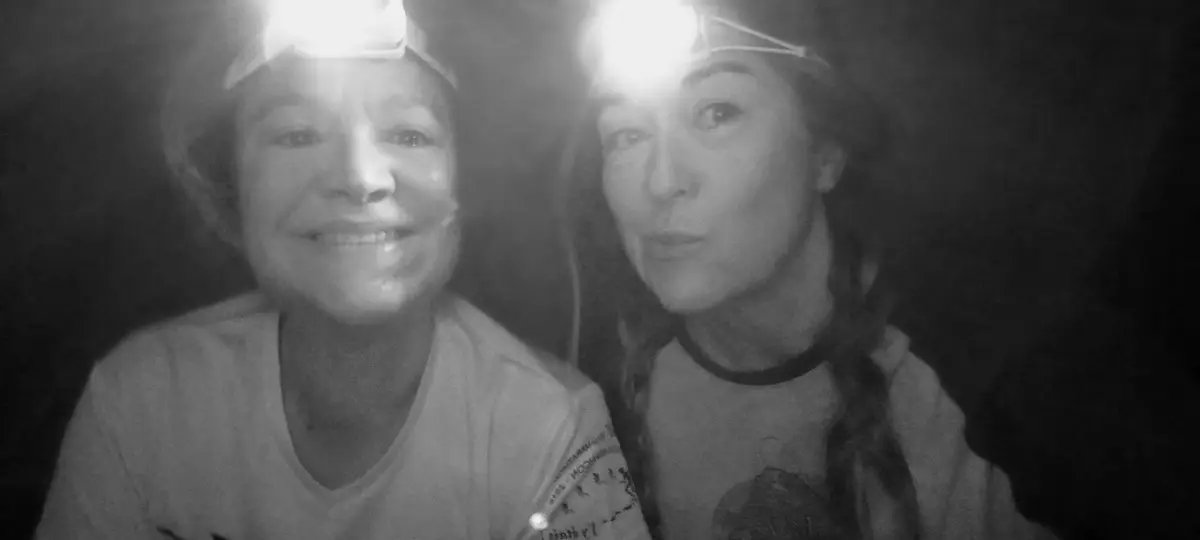 deux amies prennent un selfie sous une tente avec leurs frontales