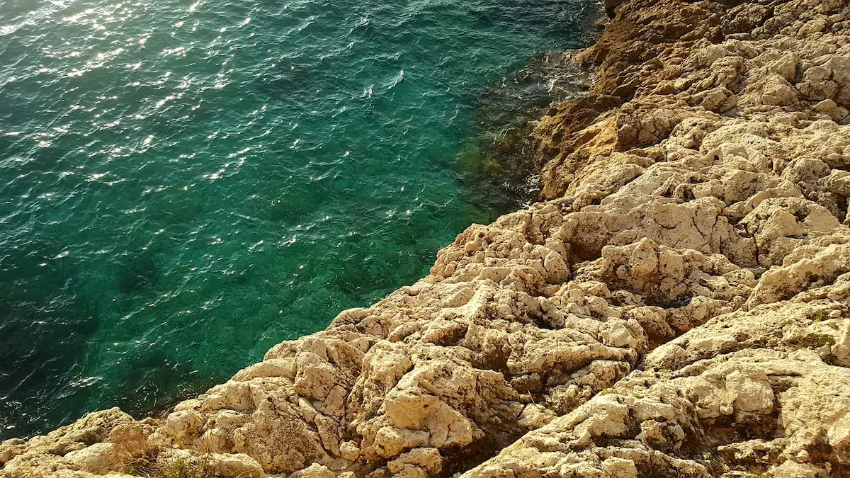 Vue des rochers sur la mer Méditerranée avec son eau sublime et du soleil qui s'y reflète