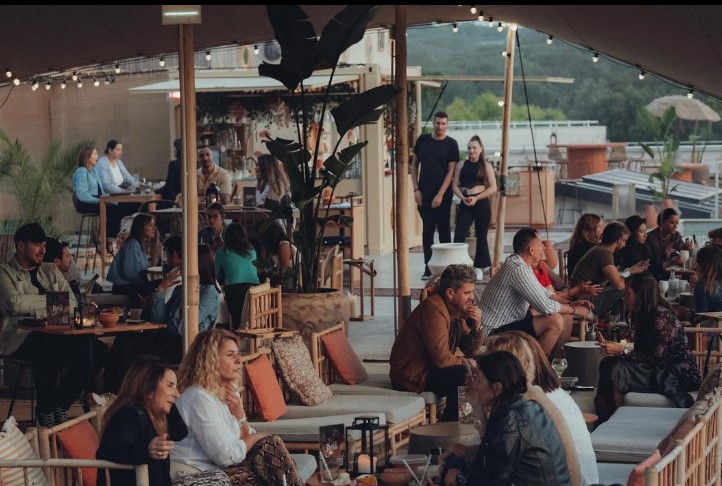 des clients du beldi rooftop installes sous la tente berbere pour discuter et siroter un verre