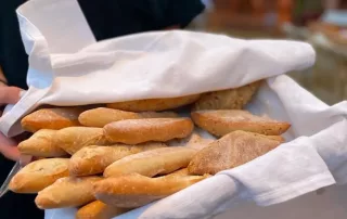 les petits batons de pain apportés dans un panier avec un service immaculé a la garoupe restaurant au cap d'antibes, un des meilleurs restaurants de la cote d'azur