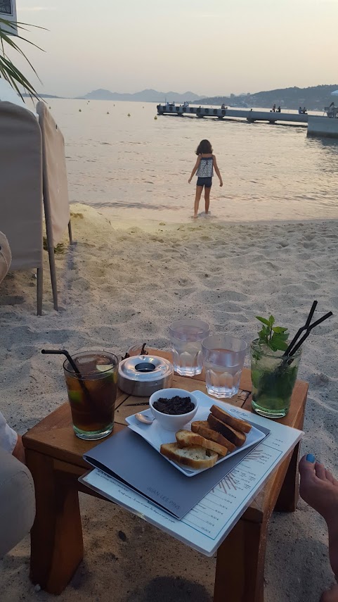 plage de la jetee a juan les pins a l'heure du coucher de soleil pour boire un verre pieds dans le sable et admirer la decoupe de l'esterel