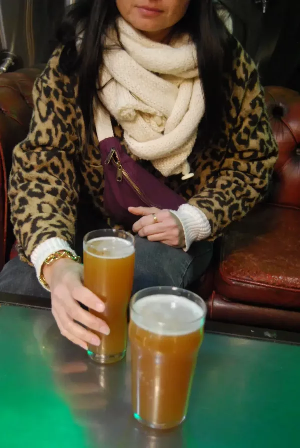photo d'une jeune femme dans une brasserie artisanale tenant une pinte de bière sur le point de la deguster