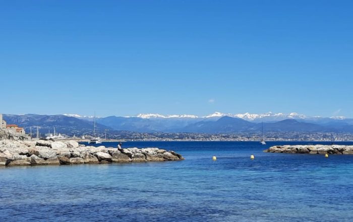 La Plage de la Salis à Antibes sur la Côte d'Azur avec ses sommets enneigés au loin