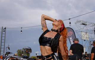 Stephanie Molly, performeuse Hell's Week Fréjus, pose sur moto Harley-Davidson orange pendant le rassemblement biker