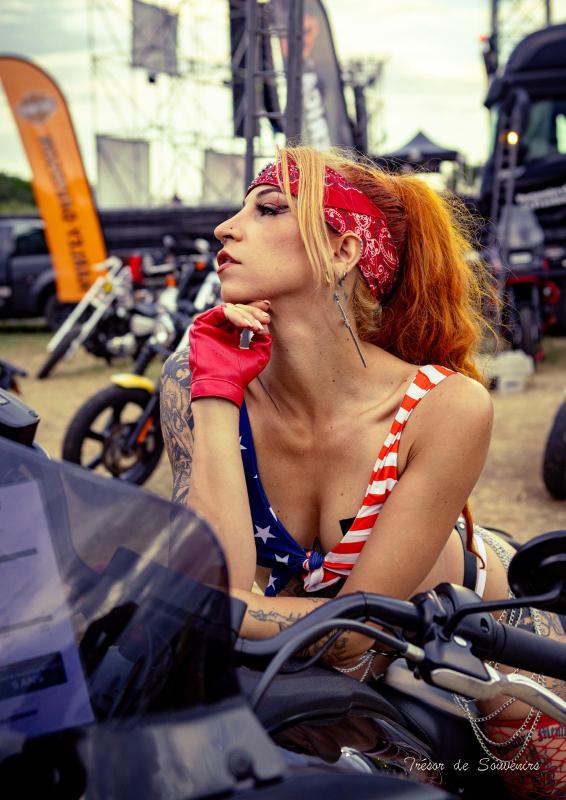 Hell's Week Fréjus 2025: Stéphanie Molly, performeuse en tenue drapeau américain, pose sur moto présente au show