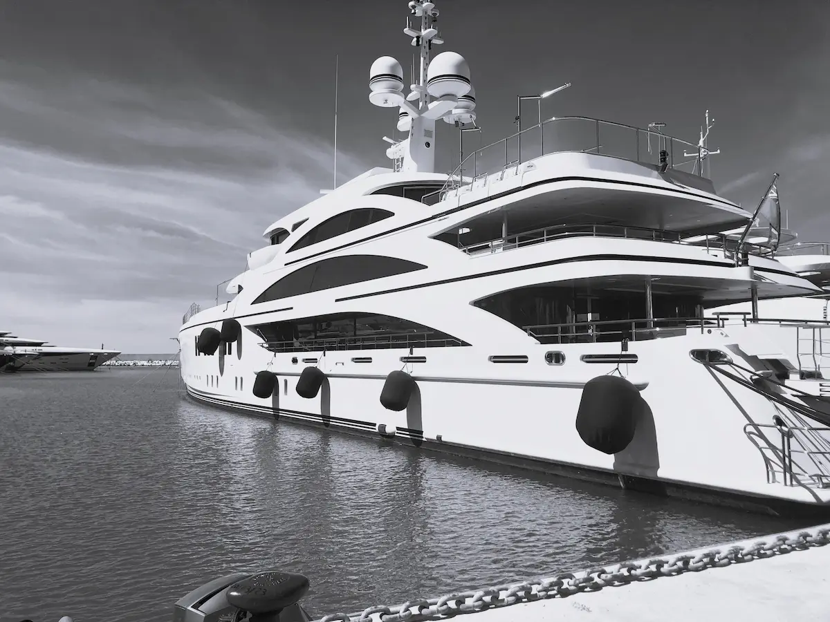 photo en noir et blanc d'un superyacht a quai illustrant les nombreux travaux de maintenance et rehabilitation de yachts supervises par marco lo cicero, fondateur de mlc yachting, un expert en reglementation et conformite dans le monde du yachting